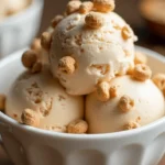 Bowl of homemade Cinnamon Toast Crunch Ice Cream topped with cereal pieces.
